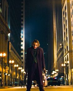 a man standing in the middle of a street at night