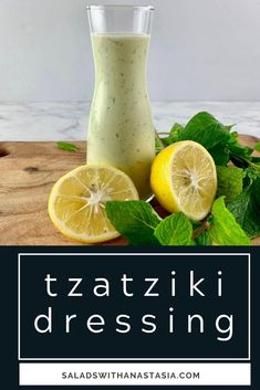 a bottle of dressing next to sliced lemons and mint leaves