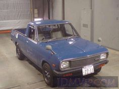 an old blue pick up truck parked in a garage