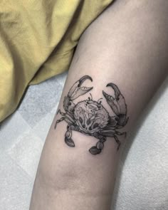 a crab tattoo on the left arm