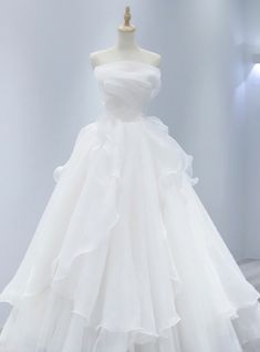 a white wedding dress on display in a room