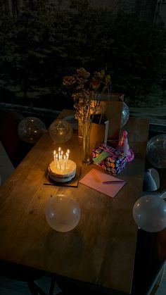 a wooden table topped with a cake covered in candles