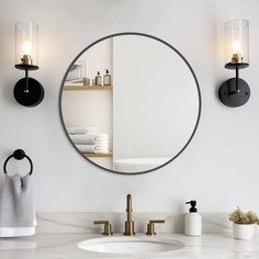 a bathroom sink with a mirror above it and towels hanging on the wall behind it