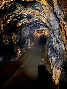 a long tunnel that is filled with lots of rocks and water at the end of it