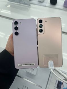 the back and front sides of two new smartphones, one in gold and one in silver