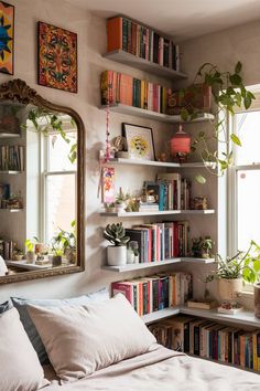 a bed sitting under a window next to a book shelf filled with lots of books