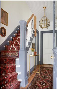 the stairs in this house are painted blue and have red rugs on each side