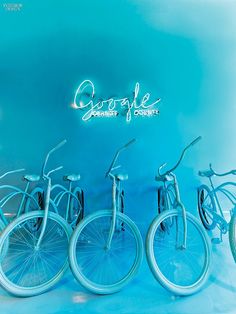 four bicycles are lined up against a blue background