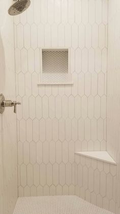 a white tiled shower with hexagonal tiles