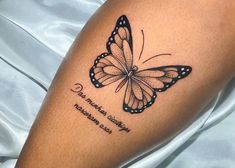 a close up of a person's leg with a butterfly tattoo on the arm