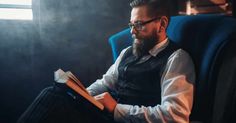 a man sitting in a chair reading a book