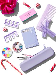 the contents of a crafting kit laid out on a white surface with candy canes, scissors and other items