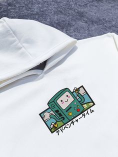 Introducing the ultimate fusion of style and nostalgia, our BMO Embroidered Hoodie brings a touch of adventure to your wardrobe.It's not just a hoodie; it's a journey back to the enchanting Land of Ooo. Looking for a unique gift for a fellow adventurer? Look no further! This personalized cartoon hoodie is sure to bring a smile to the face of any Adventurer. Embrace the Y2K aesthetic with a nostalgic twist and make a statement. Available in sizes S, M, L, and XL, this oversize hoodie ensures a co White Kawaii Hoodie With Letter Print, Kawaii Hooded Sweatshirt With Graphic Print, White Harajuku Hoodie With Cartoon Print, Kawaii Hooded Top With Graphic Print, Kawaii Graphic Print Hooded Top, White Harajuku Sweatshirt With Cartoon Print, White Kawaii Hoodie For Streetwear, White Hooded Top With Screen Print, White Embroidered Graphics Hoodie