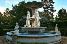 an outdoor fountain with statues around it