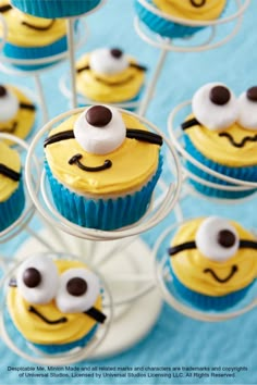 cupcakes decorated with yellow and blue frosting are arranged in the shape of bees