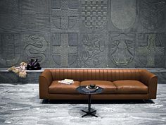 a brown leather couch sitting in front of a wall