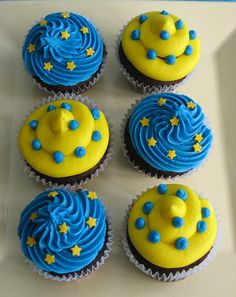 six cupcakes with blue frosting and yellow icing on a white plate