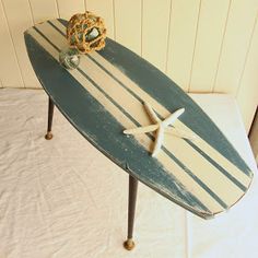 a surfboard shaped table sitting on top of a bed