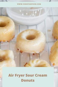 several glazed donuts cooling on a rack with the words air fryer sour cream doughnuts