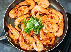 cooked shrimp and scallops in a frying pan with garnishes