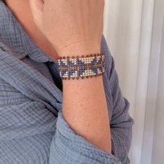 a woman is wearing a bracelet with beads on it