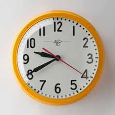 an orange and white clock with numbers on it's face is shown against a white background