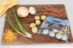 the ingredients to make this dish include onions, garlic, and bacon on a cutting board