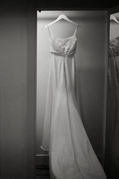 a wedding dress hanging in a closet