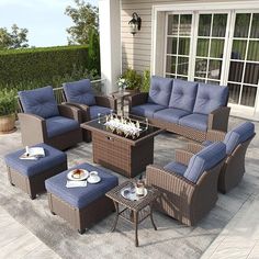 an outdoor living room with blue cushions and wicker furniture on a patio area rug