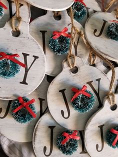 christmas ornaments are hanging from twine and decorated with red ribbon on white wooden hangers