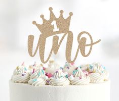 a white cake topped with a gold crown topper