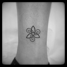 a black and white photo of a small tattoo on the ankle with an intricate design