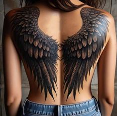 the back of a woman's body with black wings on her shoulder and chest