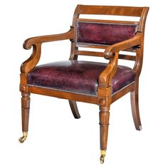 a wooden chair with purple leather upholstered on the armrests and wheels