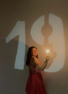 a woman in a red dress is holding a sparkler with the number ten on it