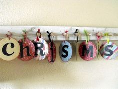 some ornaments are hanging on the wall with letters that spell out christmas and other words