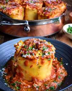 a plate with some food on it next to a pot full of sauce and other dishes