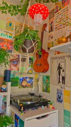 a room filled with lots of plants and pictures on the wall next to a record player