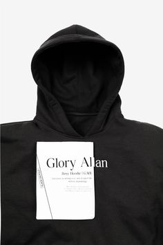 a black hoodie with a white tag on the front and back of it that says glory alan