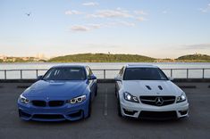 two cars parked next to each other near the water