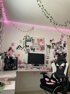 a room with a desk, chair and computer on the wall is decorated with pink lights