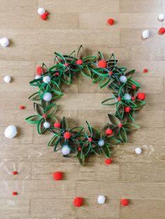 an origami wreath with red, white and blue pom - poms