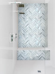 a bathroom with a glass shower door and tiled walls