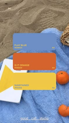 an orange is sitting on a towel next to some blue towels and two oranges