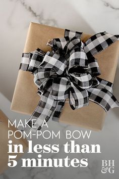 a brown box with a black and white bow on it that says make a pom - pom bow in less than 5 minutes