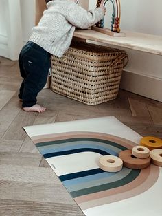 a toddler playing with toys on the floor in front of a basket and table