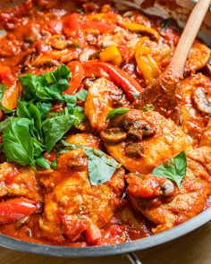 a pan filled with meat and vegetables on top of a wooden table