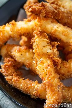 some fried food is on a black plate