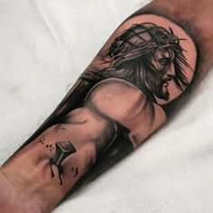 a man's arm with a jesus tattoo on it