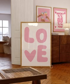 there is a pink and white love sign on the floor next to a wooden table